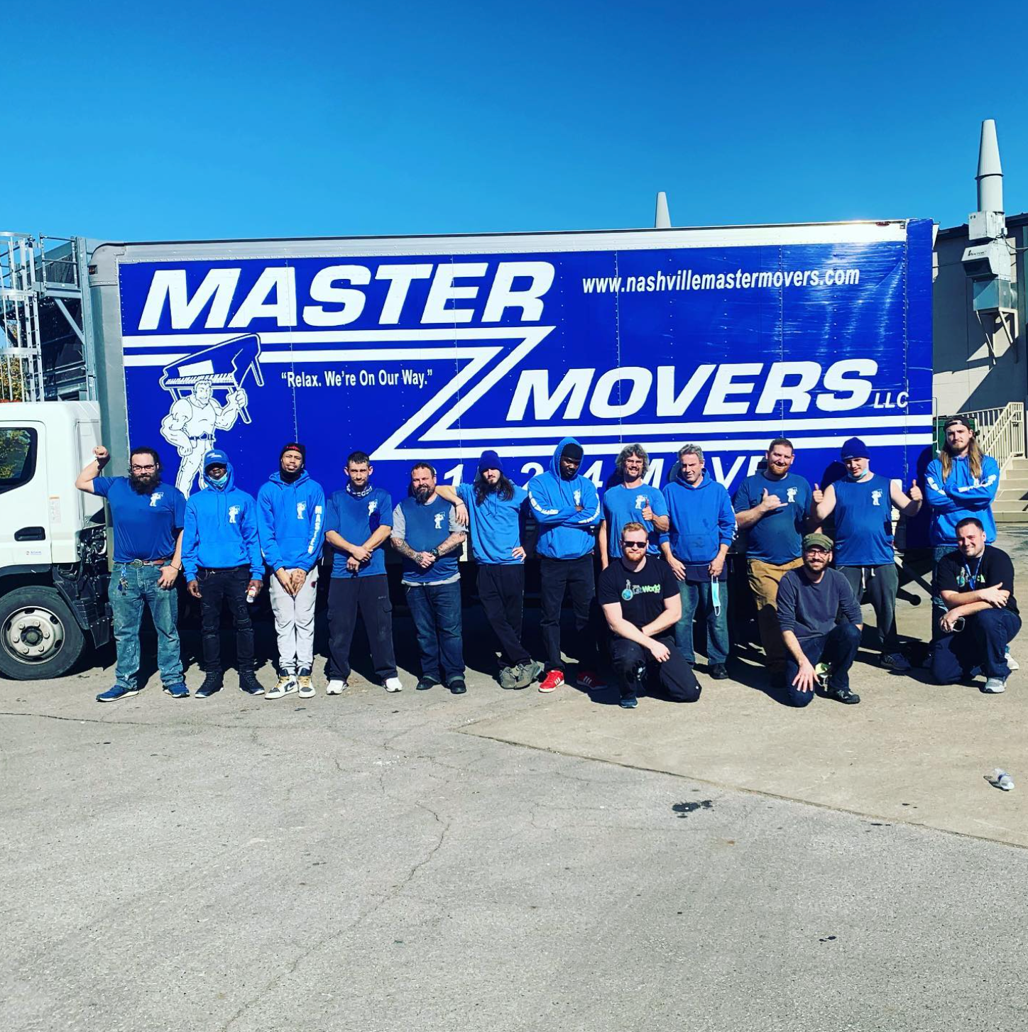 Master Movers team standing in front of a branded moving truck